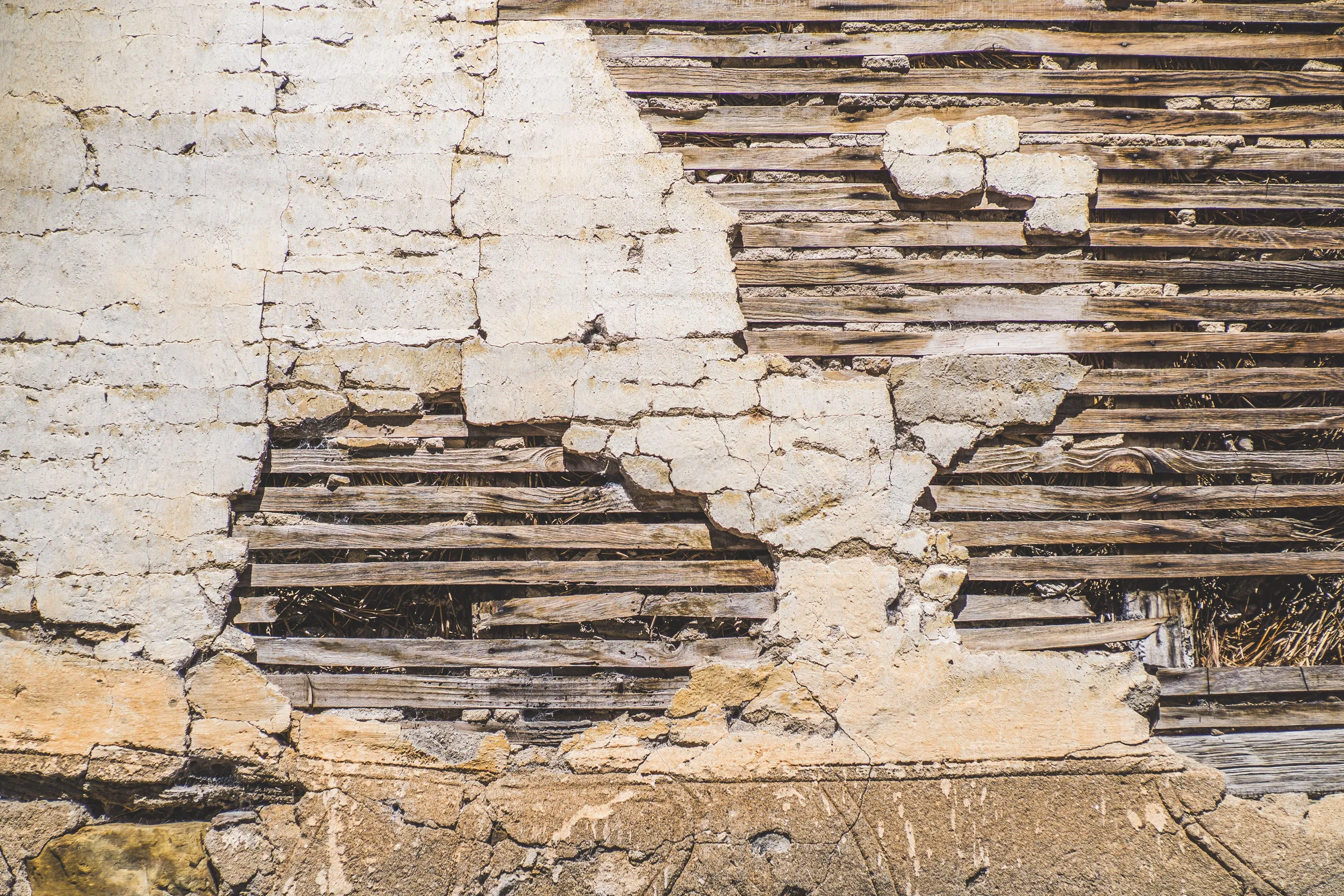 Stock photo: old plaster broken away from a wall, exposing the horizontal wooden lath behind it.
